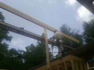 Carpenter setting a ridge beam over a new addition frame — Ice Dam Removal by Roofing Brothers in Sumatra