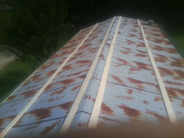 Rusted metal roof panels with new wood purlins before replacement — Storm Damage Roof Repair in Sumatra by Roofing Brothers