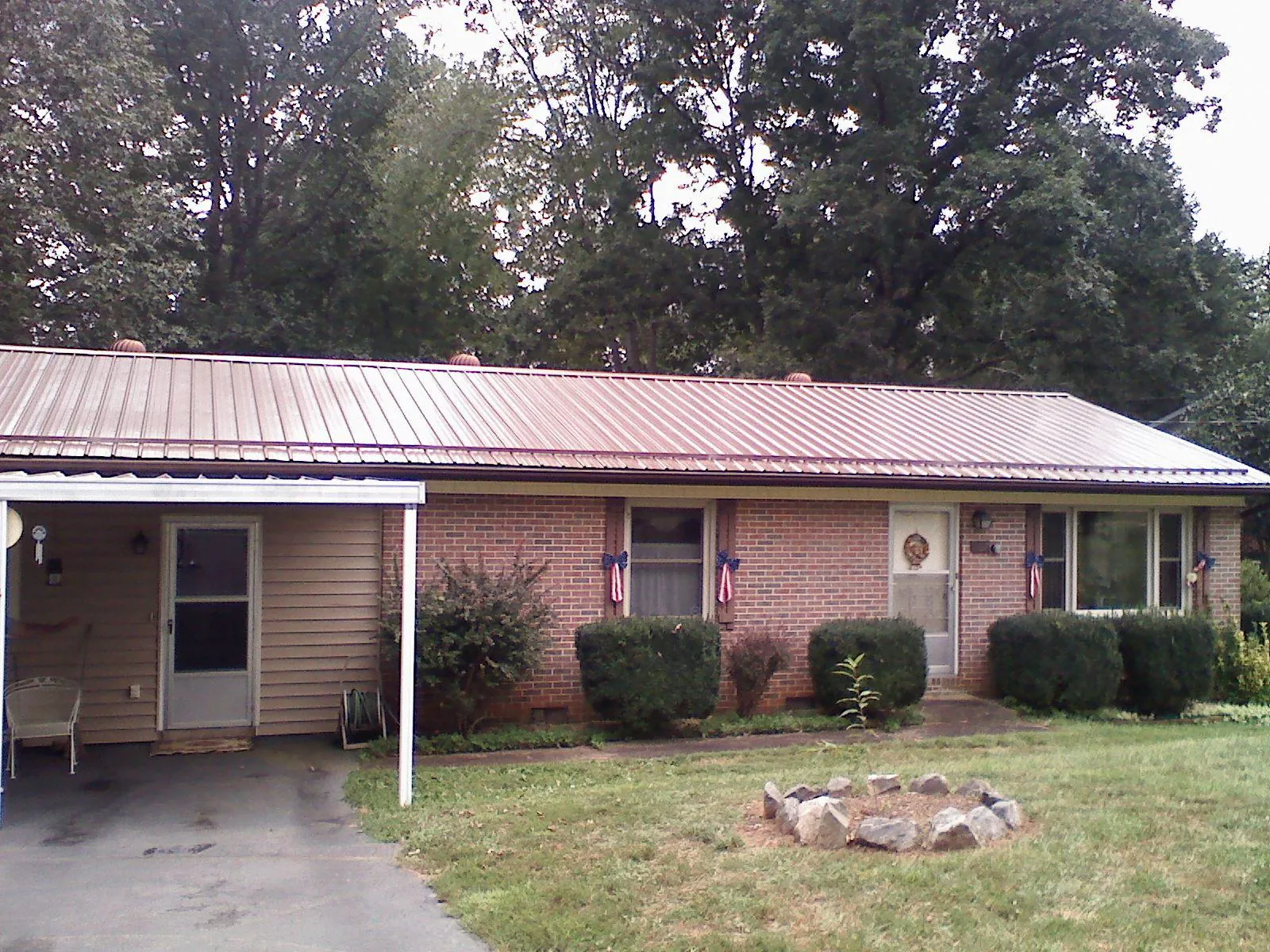 Bronze metal roof and carport on a brick ranch home — Roof Repair work by our crew in Sumatra